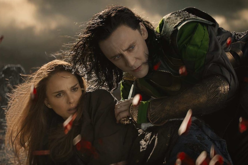 Loki protects Jane Foster as the red Aether explodes in front of them.