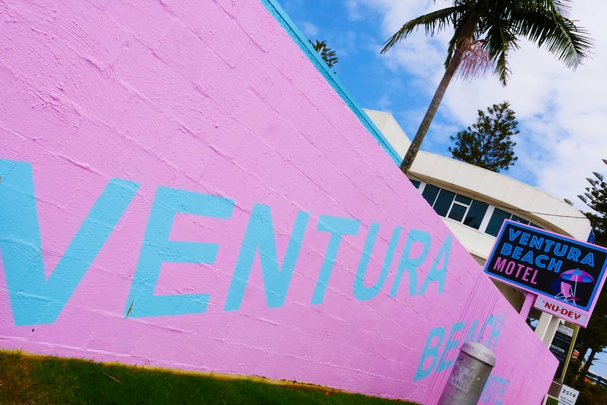 pink wall with Ventura Beach written across it, and a retro sign of the motel