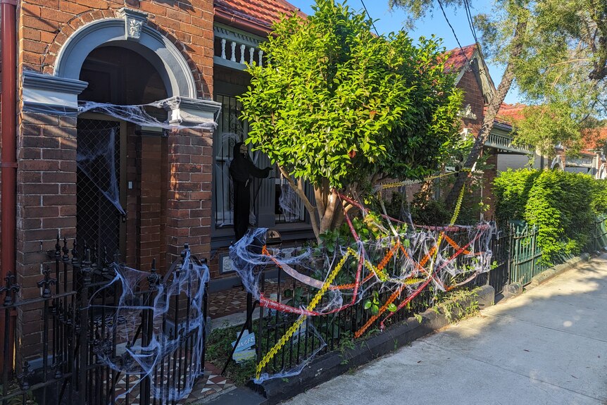 The front of a Sydney terrace house. It's decorated with cobwebs and other Halloween paraphernalia.