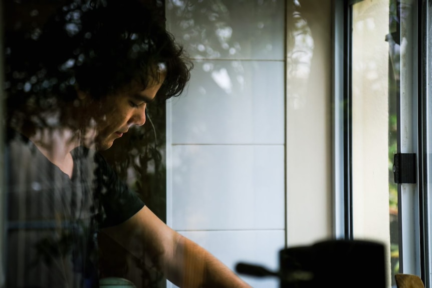 Henry can be seen washing dishes through a window