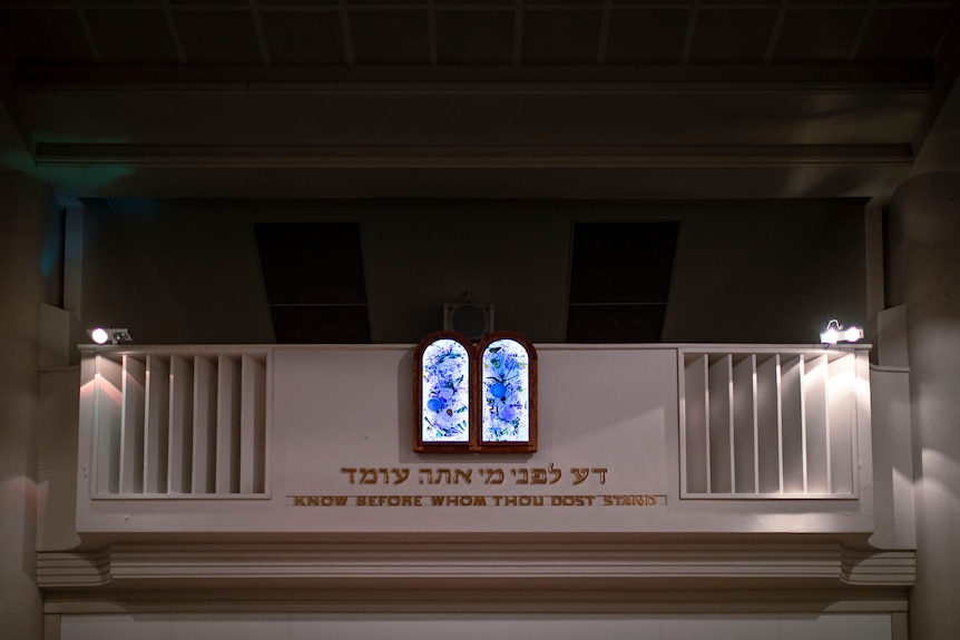Blue glass plates with Hebrew text inside a synagogue.