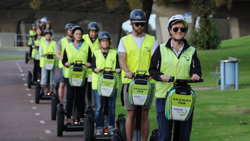 A group of people riding segways on a pathway in Perth's CBD.