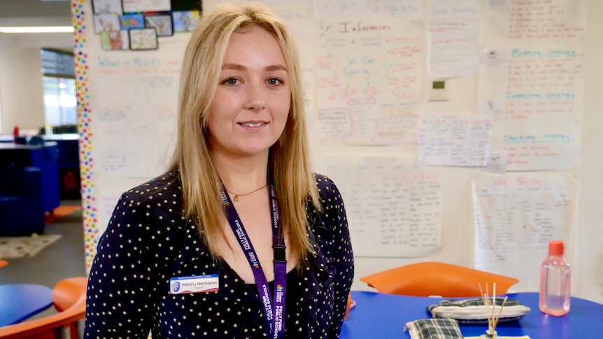 Young teacher Brittany Herrington standing in a colourful Year 5 classroom.