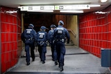 German police officers walk through an underground station.