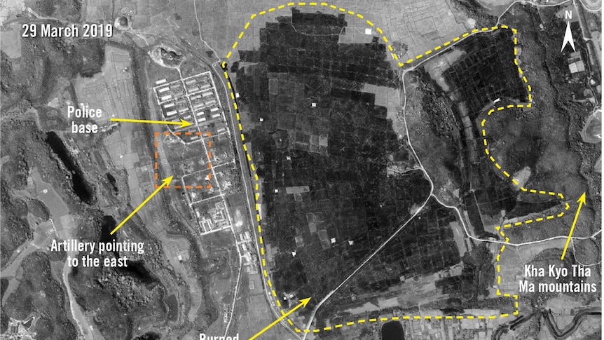 An aerial view shows burnt areas and military buildings.