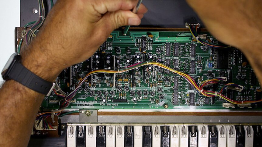 Circuit boards opened to see inside a vintage synthesizer.