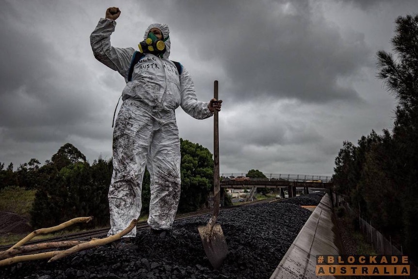 a protester on a train carrying coal