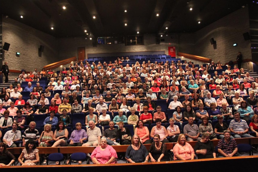 Image of a crowd seated in an auditorium. 