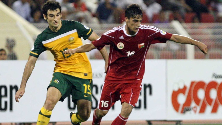 Jedinak vies for the ball with Humaid