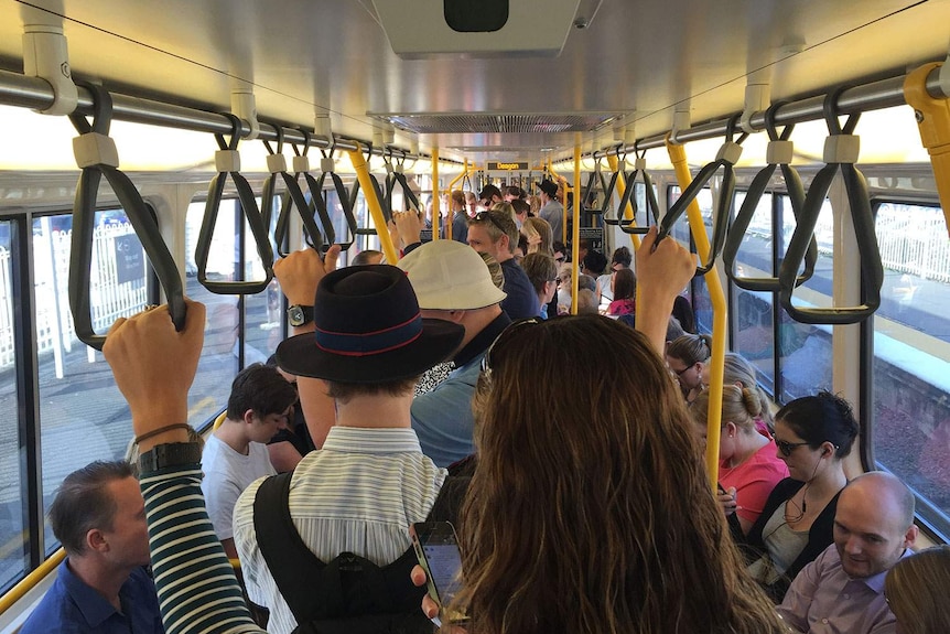 Commuters aboard a packed metro train.