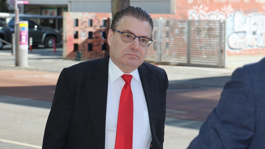 Chris Field arrives at the CCC wearing a black jacket with a red tie.