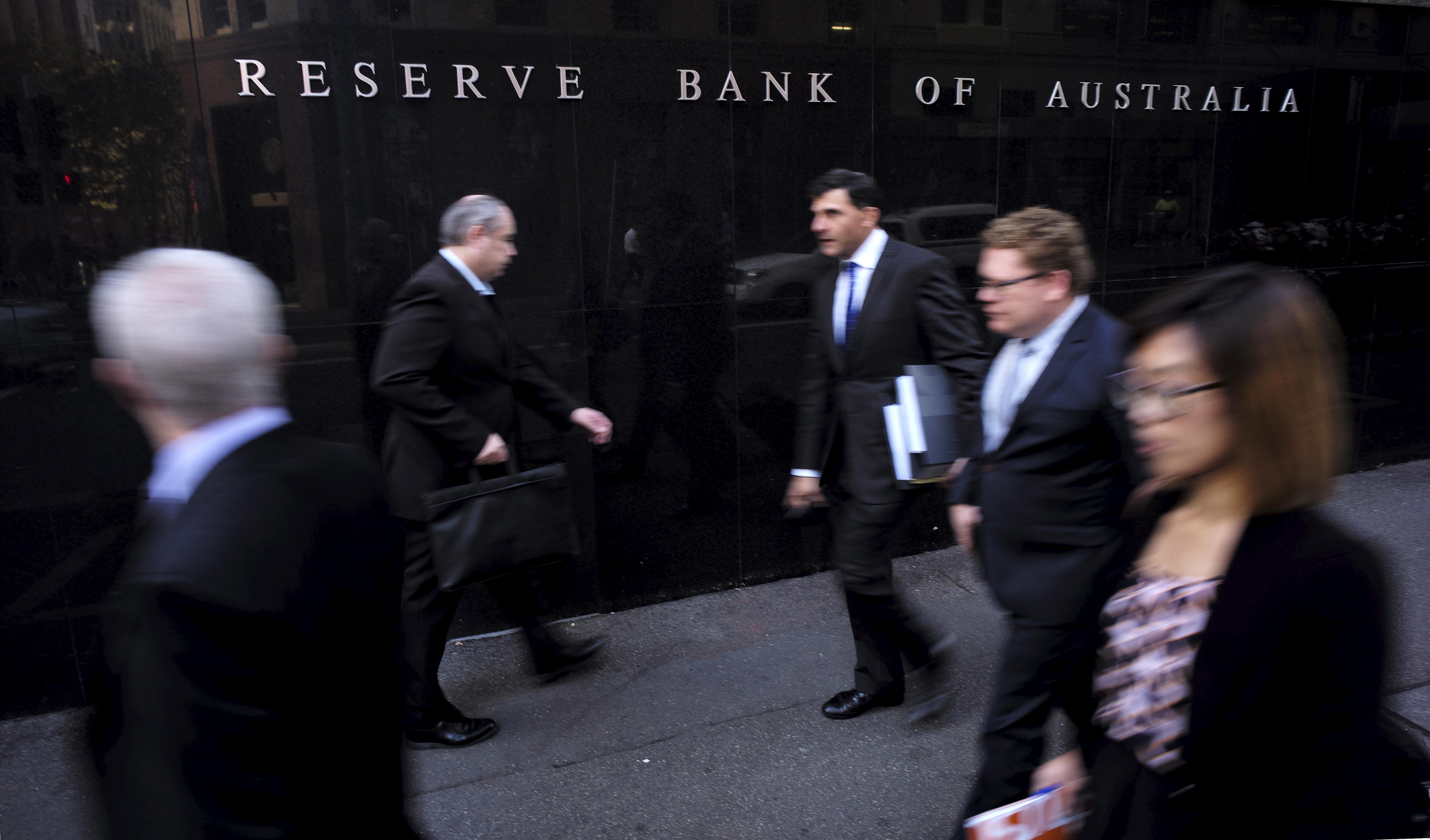 四男一女，都穿着西装，走在前面悉尼的澳大利亚储备银行大楼。” class=