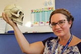 A woman holds a skull