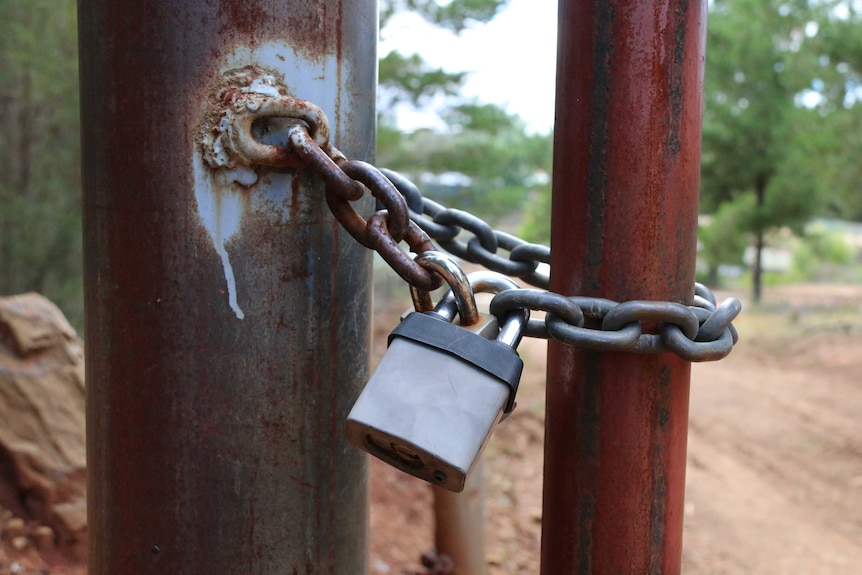 A padlock on a gate blocks vehicle access to the memorial at Fairbairn.