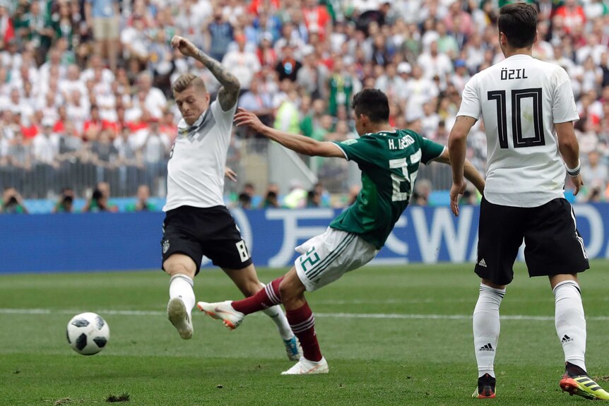 Hirving Lozano kicks the ball as Toni Kroos attempts to tackle