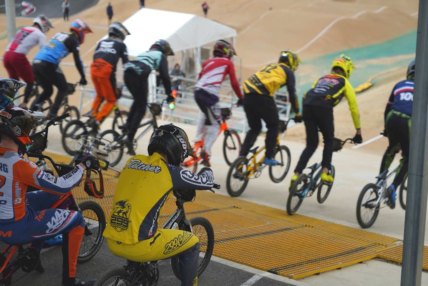 BMX riders launching into a race.