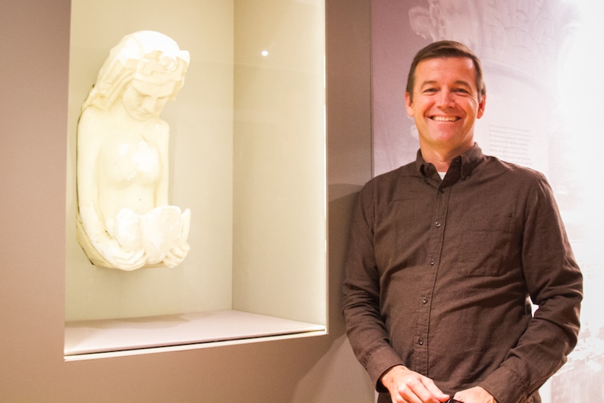 Museum of Brisbane curator Peter Denham stands next to one of the only remaining pieces of the original Cloudland theatre.