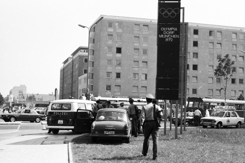 A black and white image of cars surrounding the athletes village in Munich.