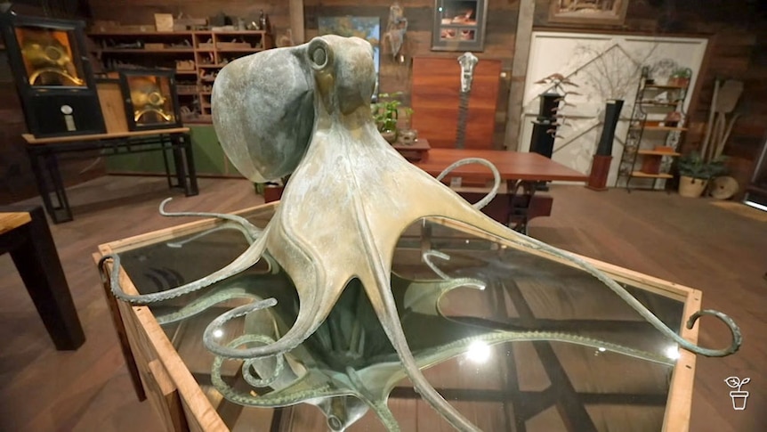 A large sculture of a squid on a glass display table.