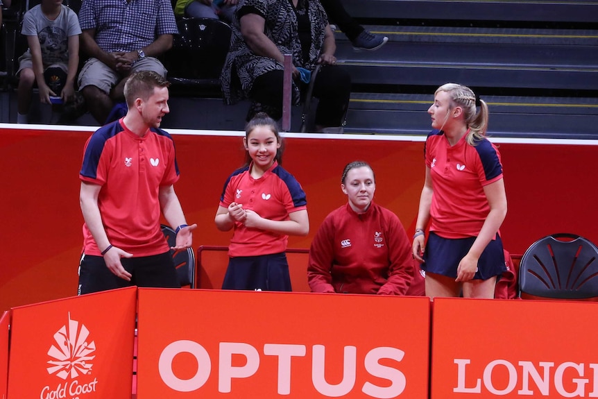 A smiling Anna Hursey with her coach and Welsh teammates