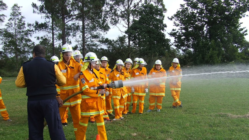 Students in full firefighter uniform using the high pressure hose during drills on the Macksville Highschool oval.