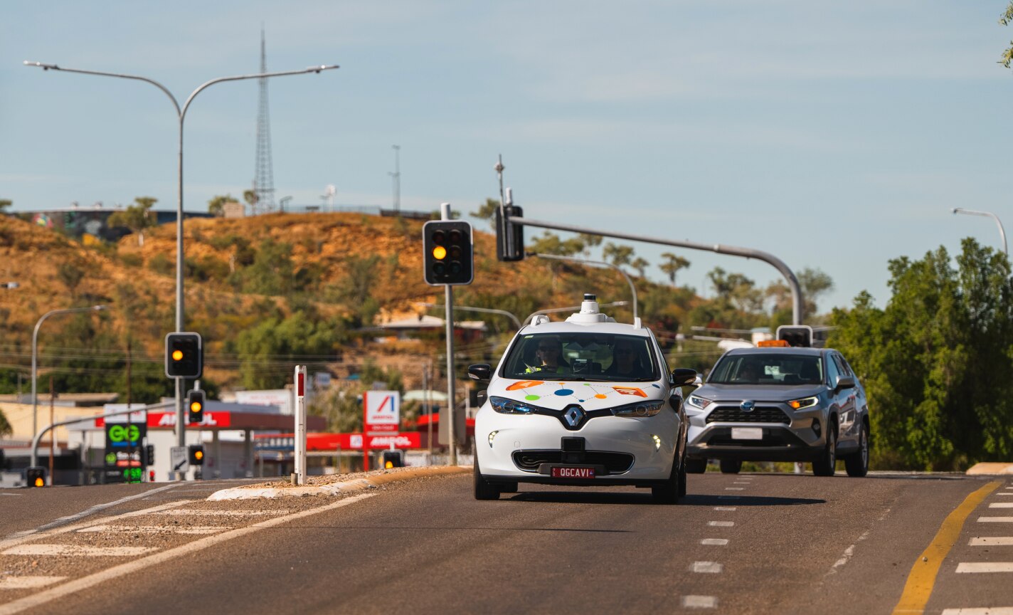 A street view of a small white car on a road