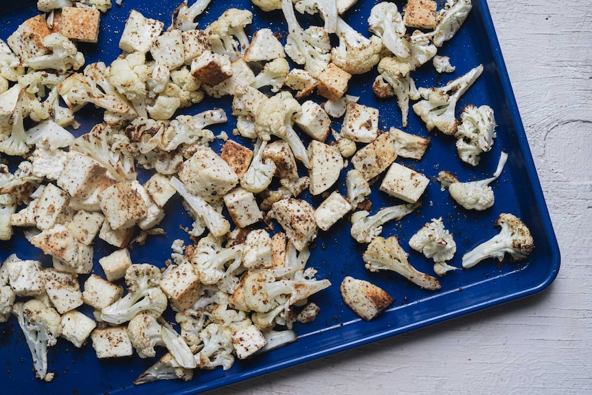 A tray of roasted cauliflower, paneer covered in mustard seed oil, ready to fill lettuce cups for a healthy dinner.