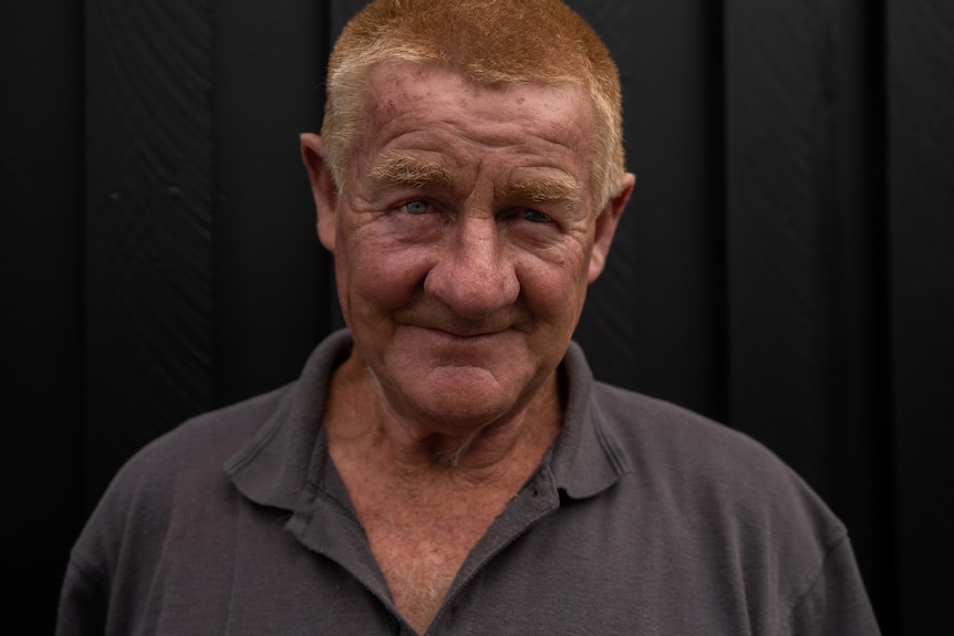 A man with short ginger hair and a weathered face looks at the camera.