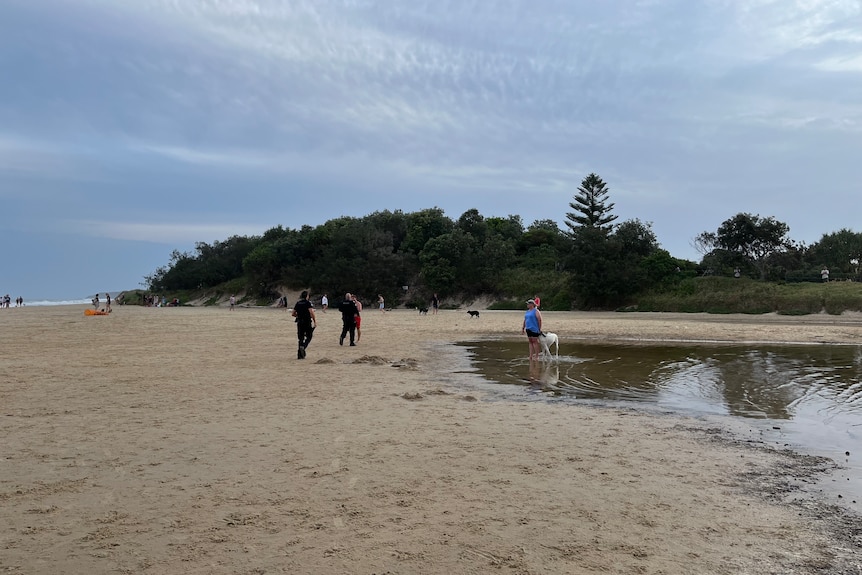 Beachgoers at Coolum Beach where a woman is believed to have drowned