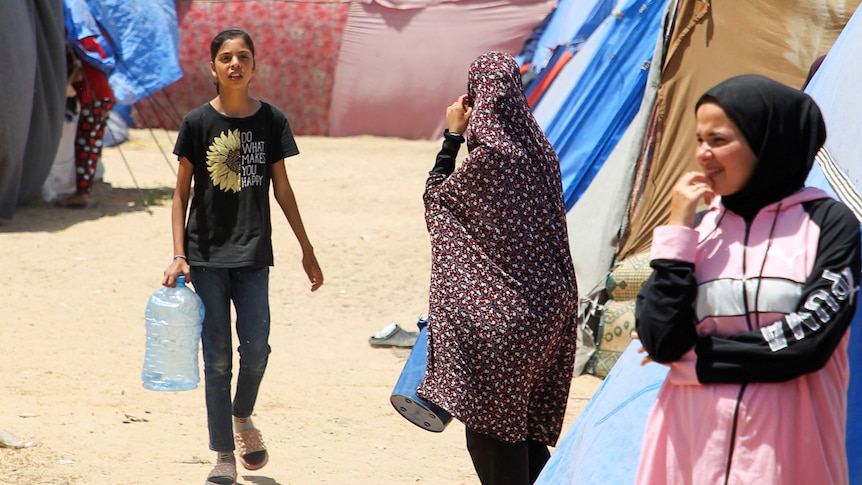 Displaced Palestinians, who fled their houses due to Israeli strikes, shelter at a tent camp in Rafah