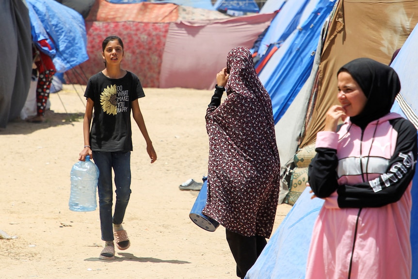Displaced Palestinians, who fled their houses due to Israeli strikes, shelter at a tent camp in Rafah