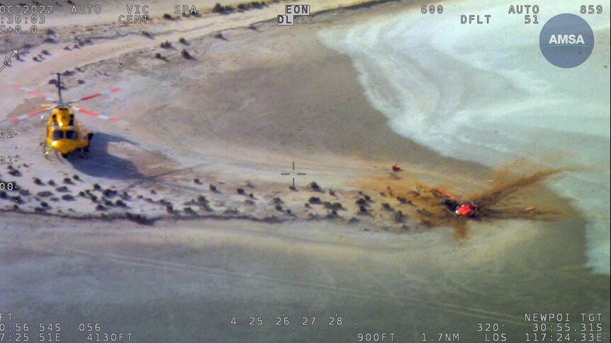 An aerial image of a helicopter at a crash site next to a lake