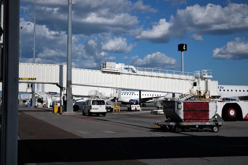 An airport aerobridge from the ground from a distance.