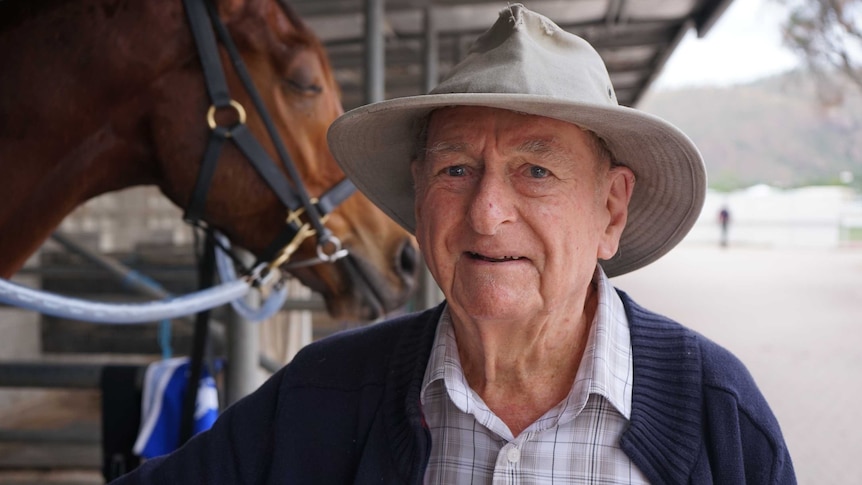 90-year-old Alf McLeod stands in front of the horse stalls at the Cluden Park racetrack in Townsville, north Queensland.