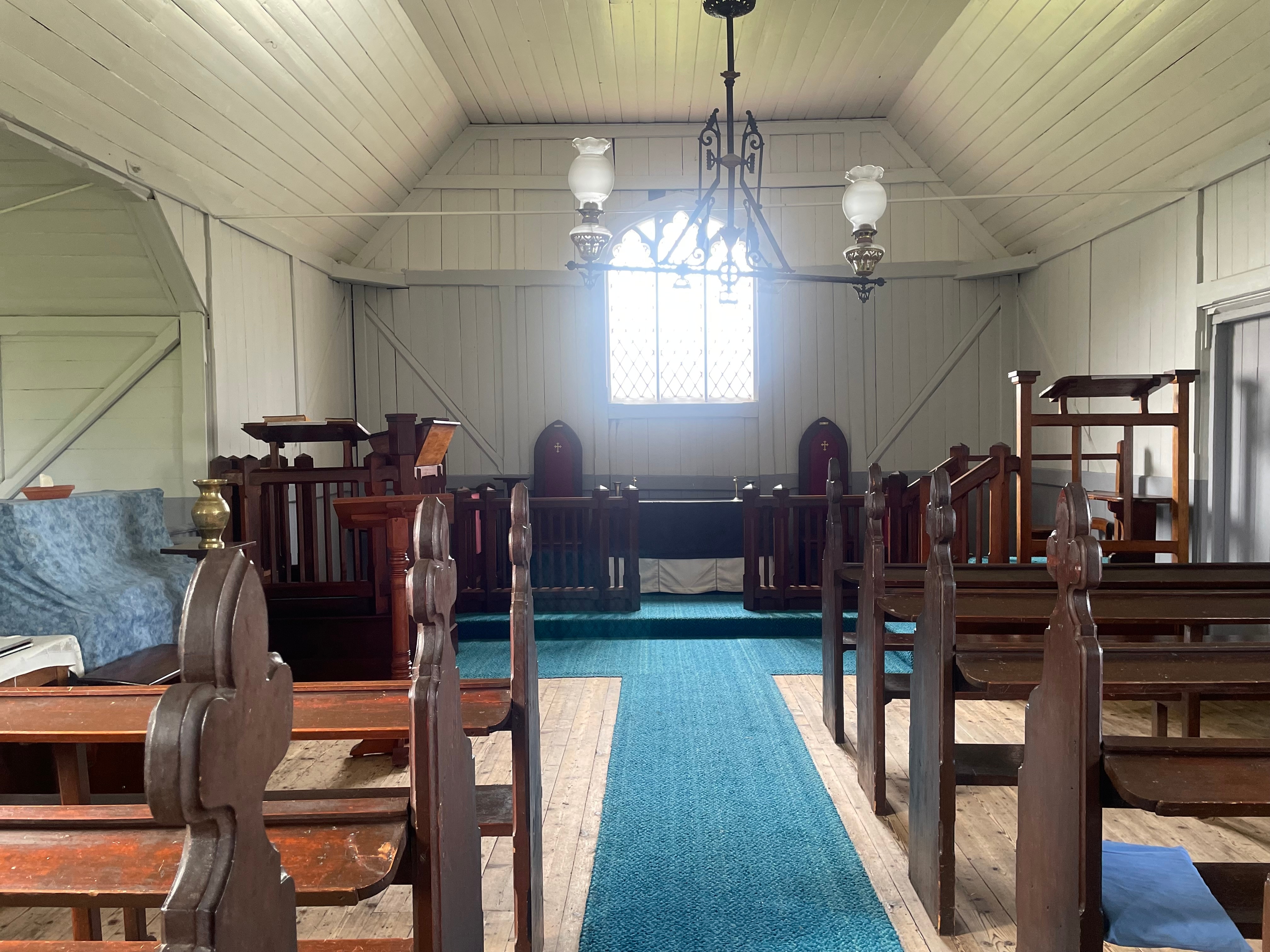 inside an old church with timber pews