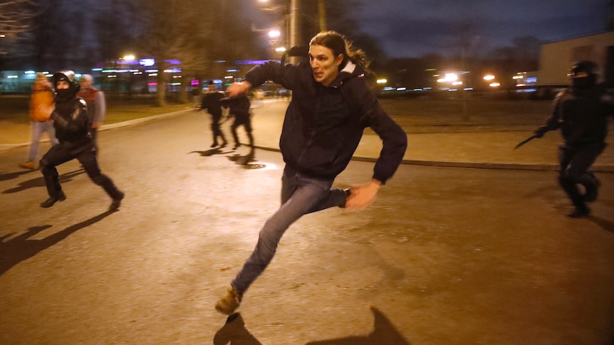A protester runs away from the police during an evening protest.
