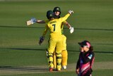 Elyse Villani and Rachael Haynes wearing yellow hug on the field as they win the match