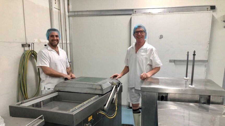 The men wearing hair nets on the processing room floor.