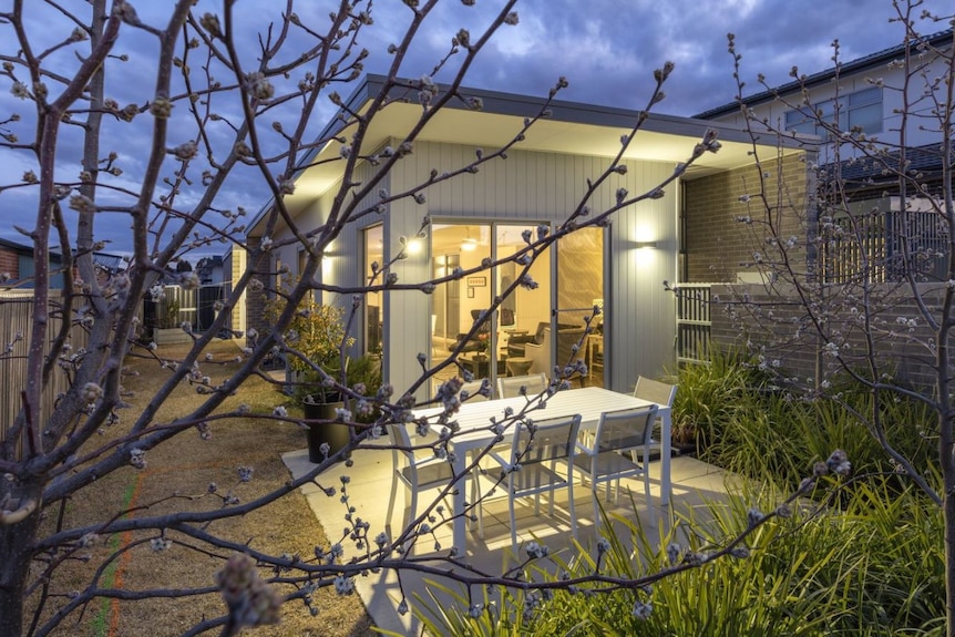 An image of the outside of a modern house with lots of windows