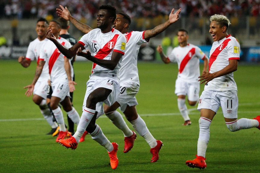 Christian Ramos and his Peru teammates run to the sideline to celebrate a goal against New Zealand.