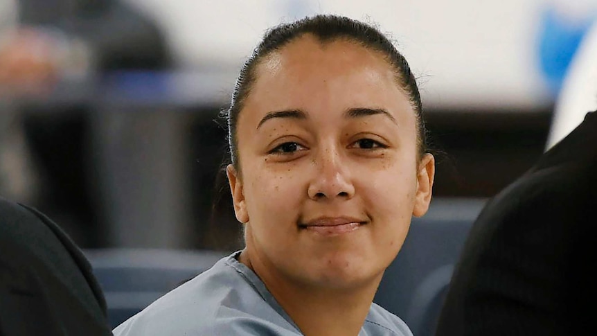 Cyntoia Brown, smiling slightly, wears a blue prison uniform