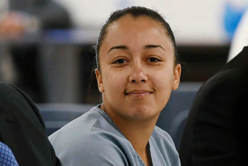 Cyntoia Brown, smiling slightly, wears a blue prison uniform