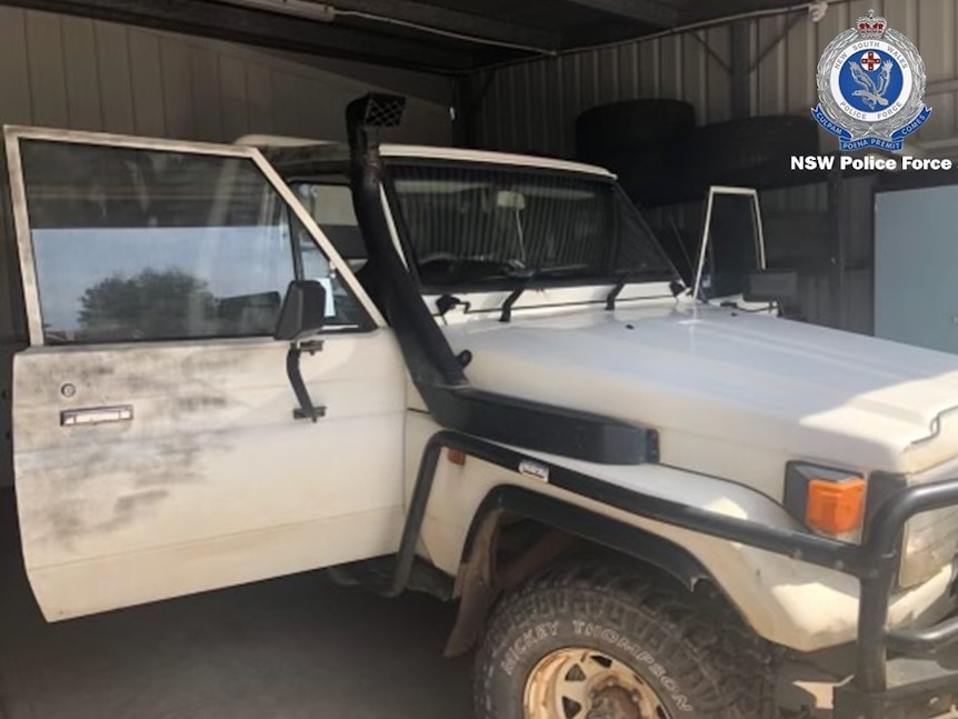 A large, light-coloured ute with a snorkel air intake. The driver's door is open and there is a police watermark on the image.