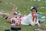 Woman laying on the grass at the Melbourne Cup.