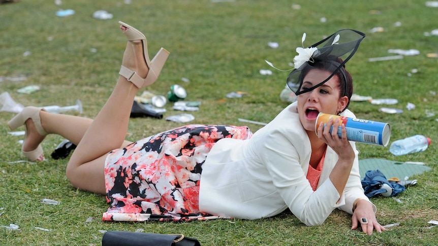 Woman laying on the grass at the Melbourne Cup.