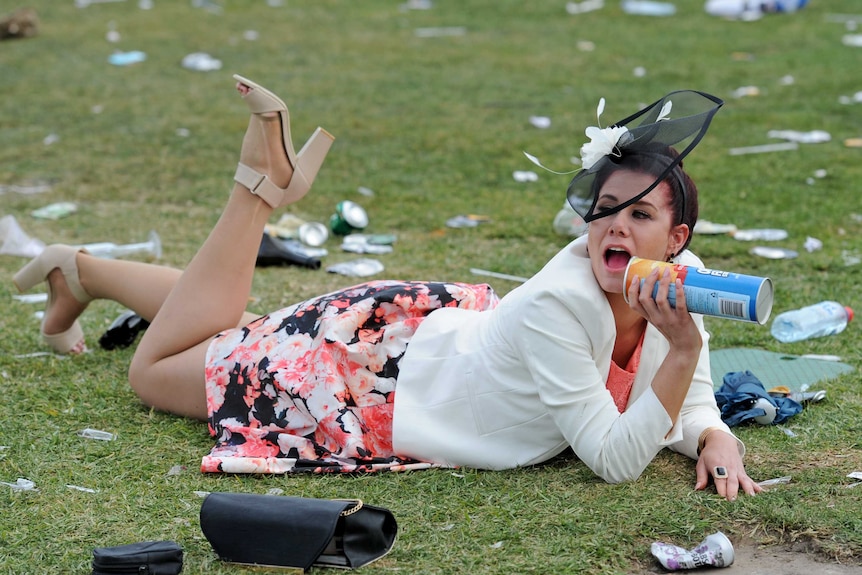 Woman laying on the grass at the Melbourne Cup.