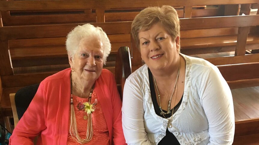 Marie McLean and her daughter Kaye Campbell sitting together in the front pew of an empty church