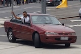 James Gargasoulas leans out of the driver's side window as he drives in circles outside Flinders Street Station.
