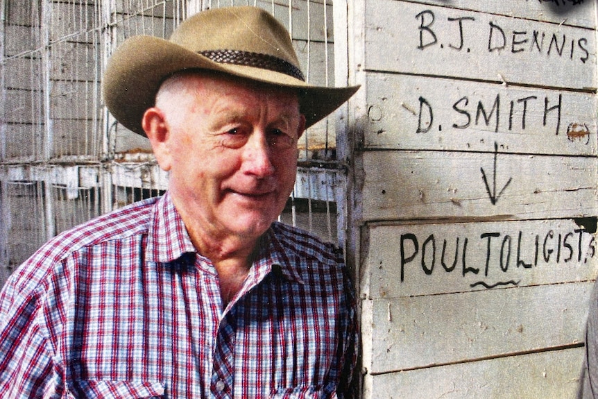 A man wearing a hat stands in a poultry pavilion