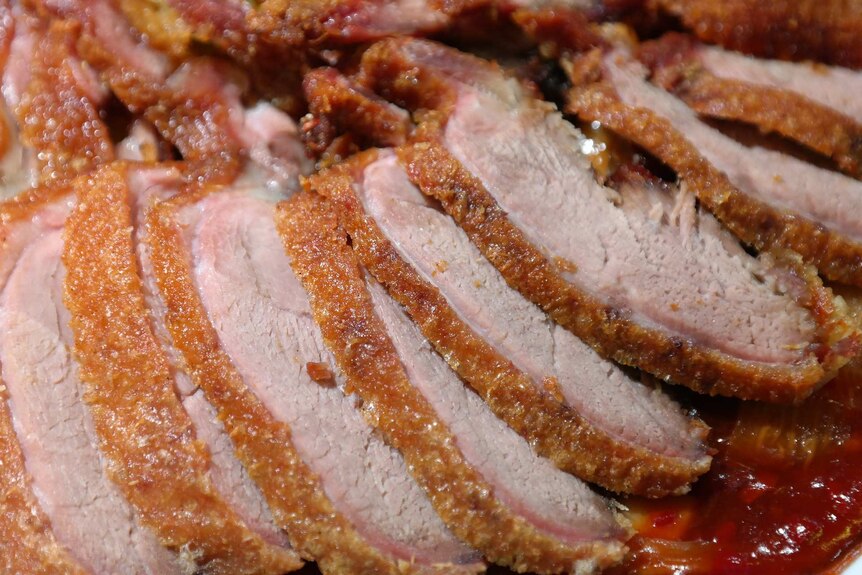 Close up of crispy skinned duck meat sliced into thin slices.